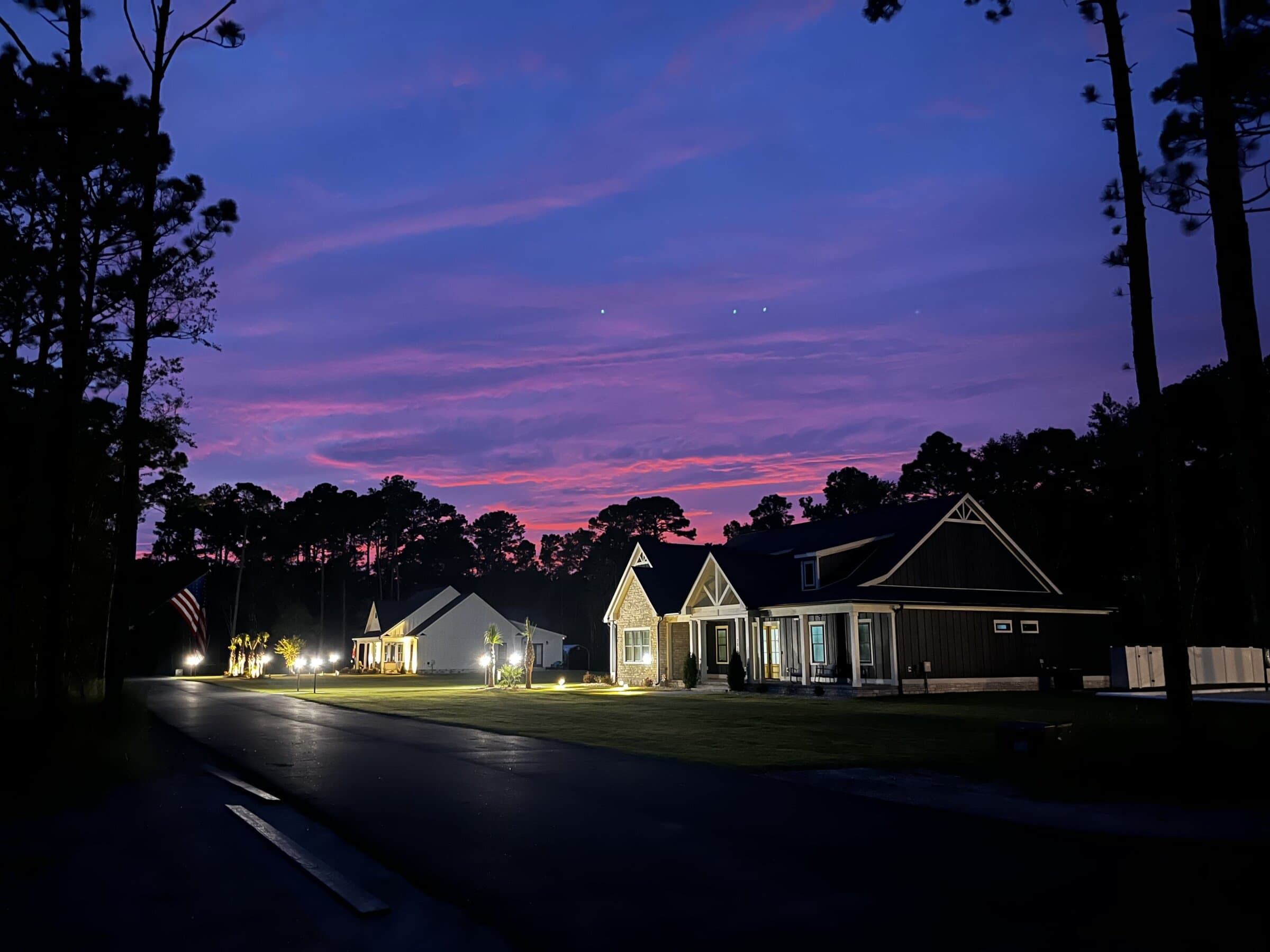A Journey Construction custom home finished at dusk with full landscape lighting