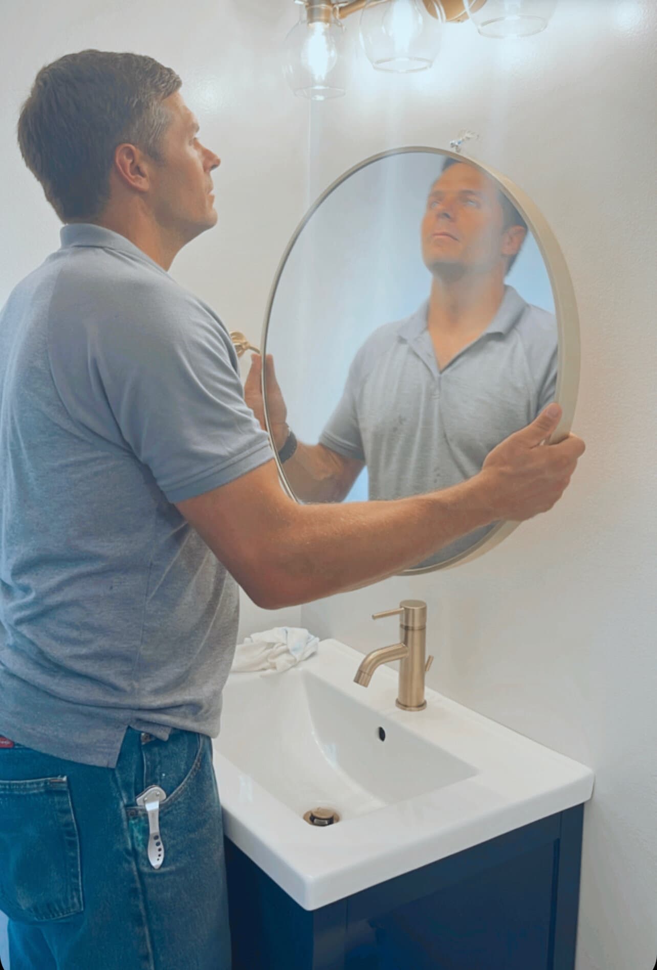 Paul installing a vanity mirror on a Journey Construction project